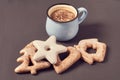 Blue mug of coffee with foam near cookies of different shapes on concrete surface