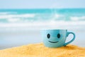 blue mug of hot coffee or tea on sand beach . Royalty Free Stock Photo