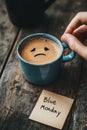 A Blue Mug with a Sad Face on the Coffee and a Note Saying Blue Monday Royalty Free Stock Photo