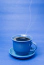 Blue mug with steaming hot coffee. Soft smoke. Blue background. Royalty Free Stock Photo