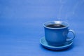 Blue mug with steaming hot coffee. Soft smoke. Blue background. Royalty Free Stock Photo