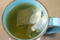 Blue mug with water and two green tea bags Royalty Free Stock Photo