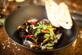 Blue mussels in white wine sauce in black bowl. Delicious healthy seafood closeup served on a table for lunch in modern