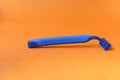 blue mustache razor with orange paper background