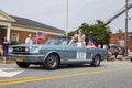 A blue mustang car driving through the fourth of July parade