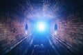 Blue mysterious light at the end of dark brick underground tunnel Royalty Free Stock Photo