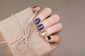 Blue nail design with gold accent. Manicured female hand