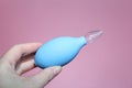 Blue nasal aspirator with glass tip in female hand