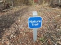 Blue nature trail sign with trail or path and trees Royalty Free Stock Photo