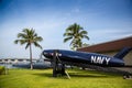 A blue Navy plane is sitting on the grass next to a building Royalty Free Stock Photo