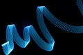 Blue neon curved wave of light as curls, swirl or spiral with dotted stripes on black background. Royalty Free Stock Photo