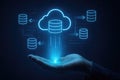 Blue neon cloud and database icons floating above an open hand with a digital network background cloud computing Royalty Free Stock Photo