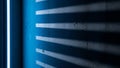 Blue neon light casting striped shadows on rough concrete wall surface Royalty Free Stock Photo