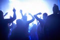 Blue, neon lights and people dancing at music festival from back, lighting and energy at live concert event. Dance, fun Royalty Free Stock Photo