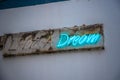 Blue neon sign Dream on a grimy wall