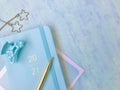 Blue new diary with golden 2021 words, golden pen, blue hairpin, golden jewelry, blue background. close up.