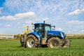 Blue modern tractor pulling a chafer crop sprayer Royalty Free Stock Photo