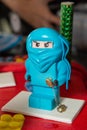 Blue ninja lego mini figure on birthday cake.