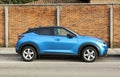 Blue Nissan Juke, hybrid model of the japanese automaker. Brick wall background.