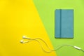 Blue note book with white earphone on green yellow education colorful background