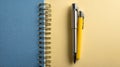 Blue Notepad and Yellow Pen on Yellow Background Royalty Free Stock Photo