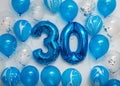 Blue number 30 celebration foil balloons with helium balloons on white background. Party decoration for happy birthday celebration