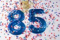 Blue number 85 with colorful confetti