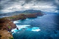 Blue ocean, mountains, rocks, windmills and cloudy sky