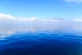 Blue ocean water with clouds in the background