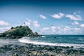 Blue ocean waves sweeping towards the rocky coast the lighthouse on mountain