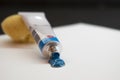 Blue oil paint, tube and brush on white paper Royalty Free Stock Photo