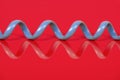 Blue old fashioned spiral phone cable on a red background