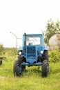 blue old MTZ 53 tractor on orchard, simple mechanical technology agricultural vehicle