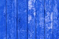 Blue old painted peeling vertical fence boards. Front view.