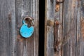 Blue old rusty unlocked padlock on wooden door Royalty Free Stock Photo