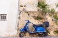 Blue old scooter parked by the wall in the empty street Chania Crete