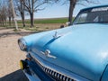 Blue old soviet car GAZ M21 Volga / GAZ-21 oldtimer parked on the road in spring sunny weather