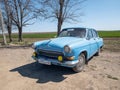Blue old soviet car GAZ M21 Volga / GAZ-21 oldtimer parked on the road in spring sunny weather
