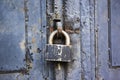 A blue old wooden door with a rusty steel lock. Farm gate from planks with an old padlock. The lock on the door Royalty Free Stock Photo