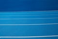 Blue Olympic track lanes with white stripes, an empty background suitable for copy space, represent the concept of physical sports Royalty Free Stock Photo