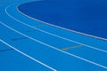 Blue Olympic track lanes with white stripes, an empty background suitable for copy space, represent the concept of physical sports Royalty Free Stock Photo