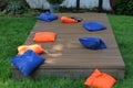Blue and orange cornhole bags on a board during a backyard game Royalty Free Stock Photo