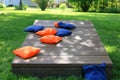 Blue and orange cornhole bags on a board during a backyard game Royalty Free Stock Photo