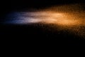 Blue orange dust particles explosion on black background. Royalty Free Stock Photo