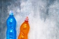 Blue and orange isotonic energy drink on gray-blue background. Top view, copy space Royalty Free Stock Photo