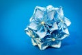 Blue origami flower ball on the blue background Royalty Free Stock Photo