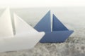 Blue origami ship wins on white ships; concept of success in business