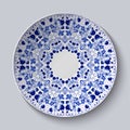 Blue ornament of berries and flowers. Pattern is applied on a ceramic plate.