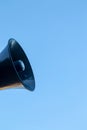 Blue outdoor loudspeaker or horn megaphone for important public information against blue sky at beach of Lloret de Mar. Catalonia