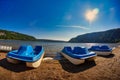 Blue paddle boats on the sandy shore of a lake Royalty Free Stock Photo